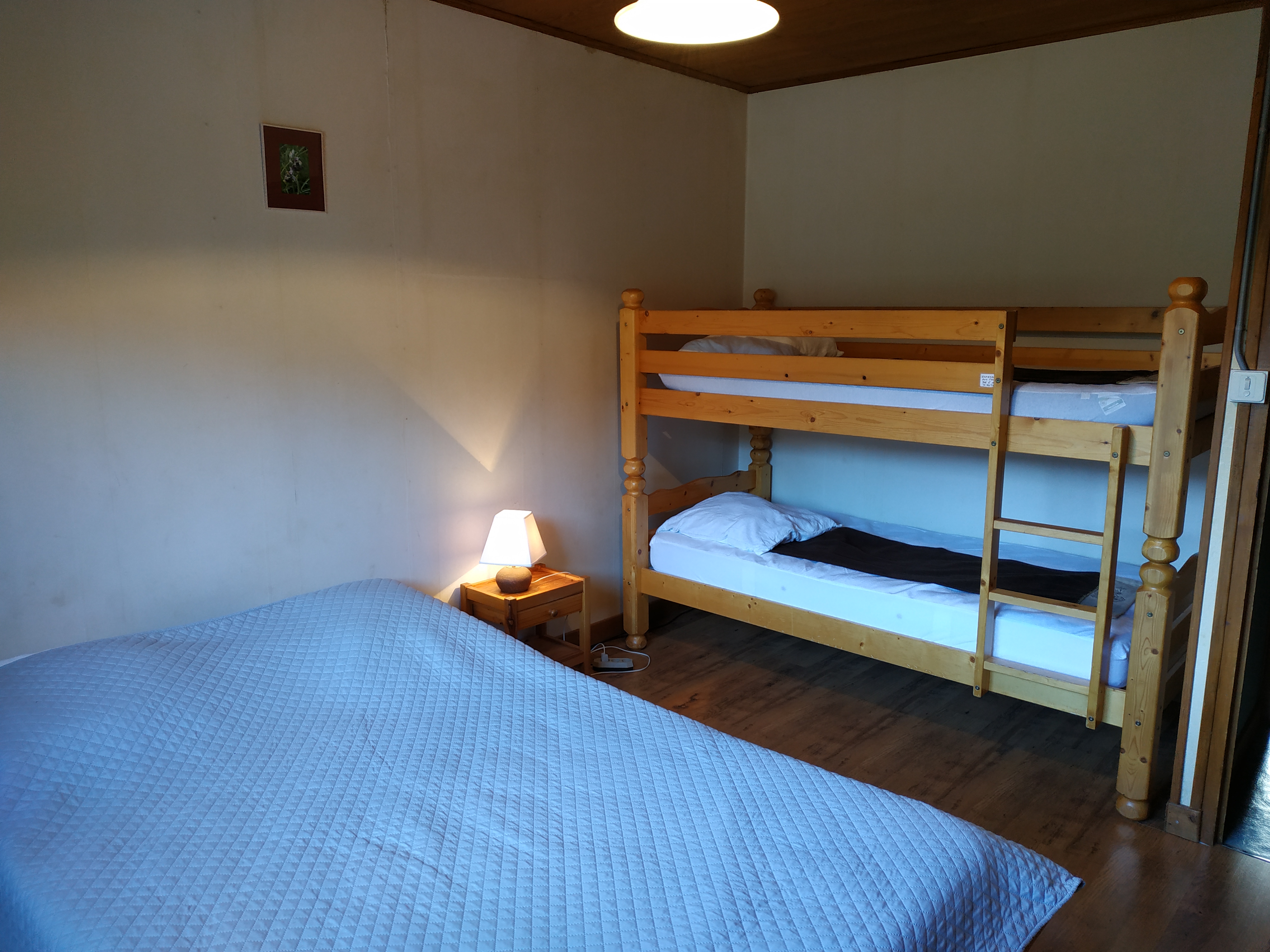 Chambre Chamechaude avec un lit double, deux lits simples superposés et un lavabo